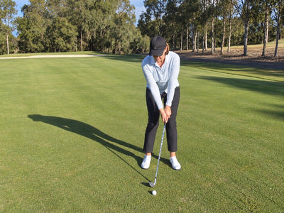 Anne Rollo practising a short pitch beside a green