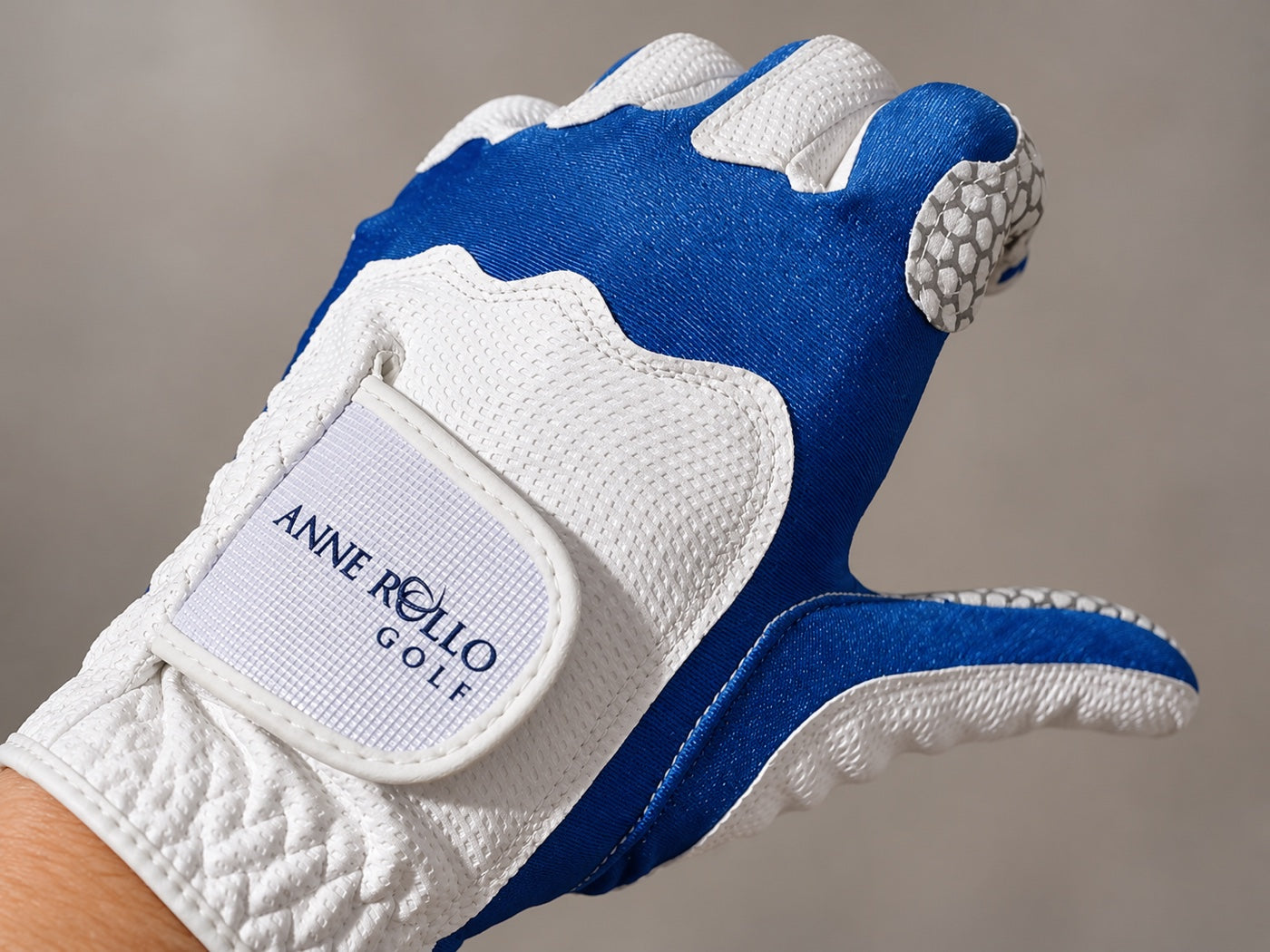 Blue and white Anne Rollo Golf glove worn on a hand