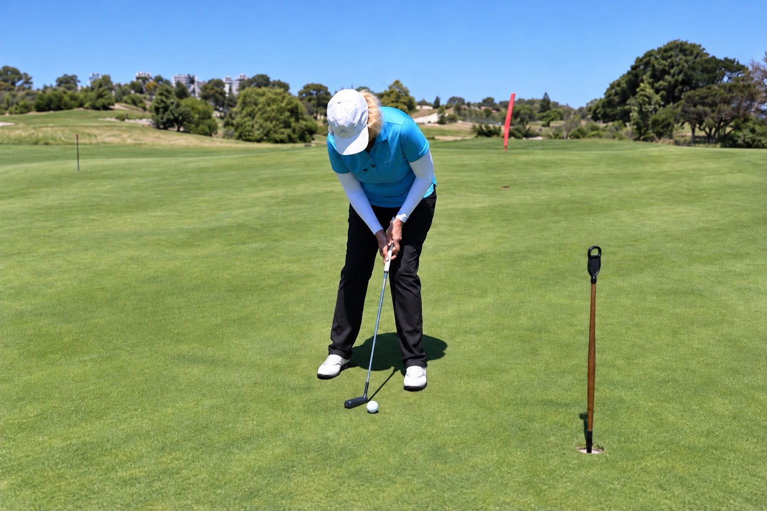 Anne Rollo addressing a short putt on a practice green