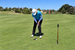 Anne Rollo addressing a short putt on a practice green